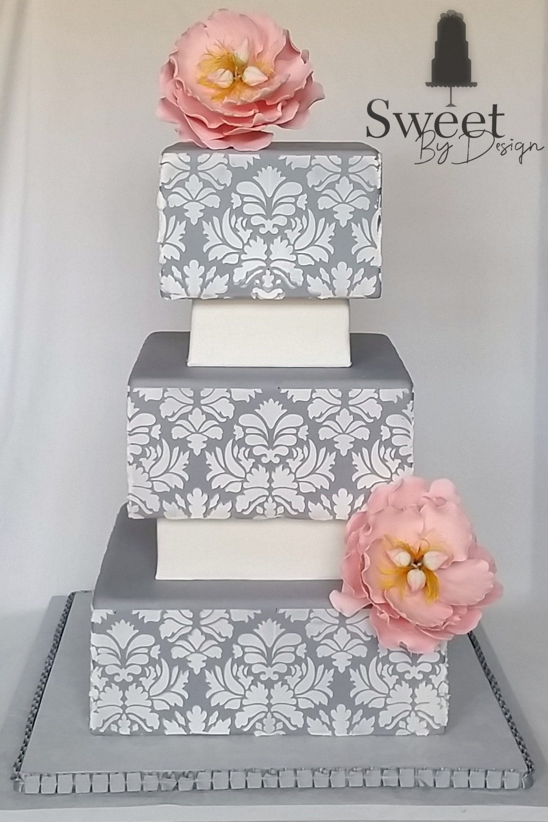 Grey and white damask wedding cake with pink fondant flowers by Sweet By Design