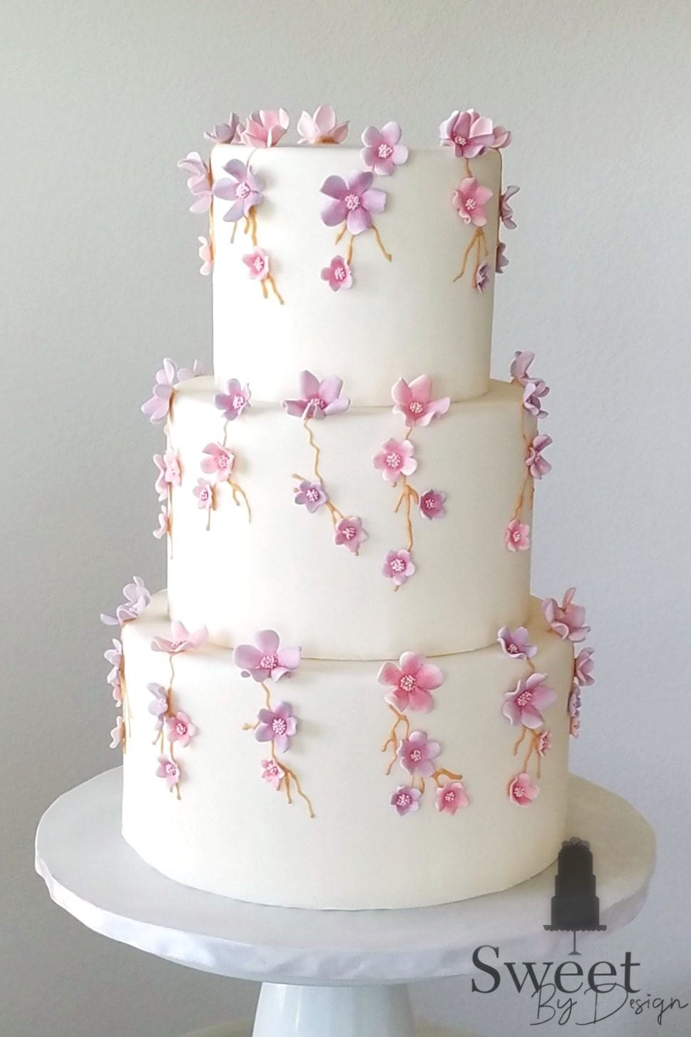 Pink and lavender flower wedding cake by Sweet By Design